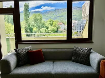 a couch sitting in a room with a large window at 15% Discount! Limited Time in Sofia