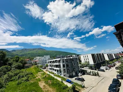 a city street with buildings and a mountain in the background at 15% Discount! Limited Time in Sofia