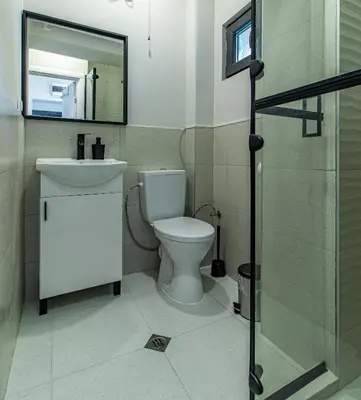 a bathroom with a toilet and a sink and a mirror at Stay Central: Urban Studio Gem in Sofia