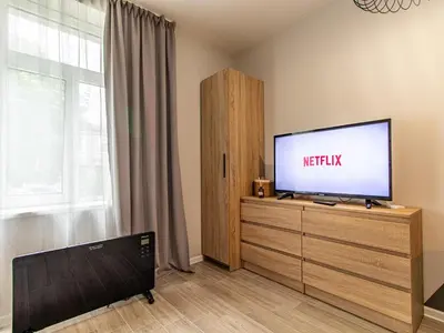 a living room with a flat screen tv on a dresser at Stay Central: Urban Studio Gem in Sofia