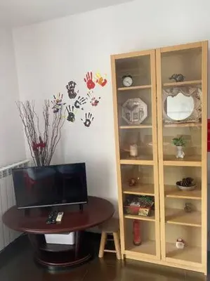 a wooden cabinet with a tv and a table at New Two Bedroom apartment with balcony in Sofia