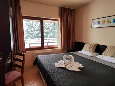 a room with a bed with a towel on it at Panorama Stoykite Orpheus in Stoykite