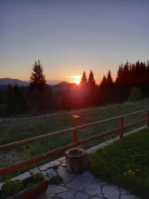 a sunset in a field with a wooden fence at Panorama Stoykite Orpheus in Stoykite