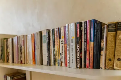 a row of books sitting on a shelf at Elegant 1-Bedroom Apartment in Plovdiv