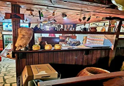 a cat standing on a counter in a restaurant at Хотел Механа Воденицата in Zlatkov Chiflik