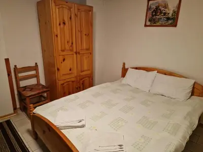 a bedroom with a bed and a wooden cabinet at Хотел Механа Воденицата in Zlatkov Chiflik