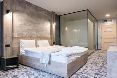 a bedroom with a large bed and a glass wall at RCR Einstein studios in Sofia