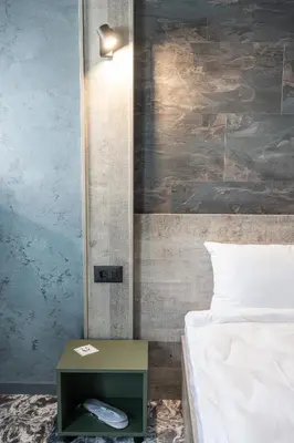 a bedroom with a bed and a night stand next to a side table at RCR Einstein studios in Sofia