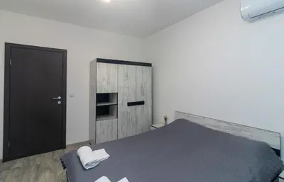 a bedroom with a bed and a wooden door at Stylish 2 BDR Apartment at an Excellent Location in Sofia