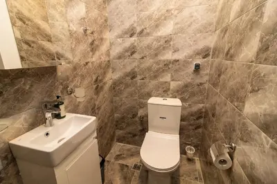 a bathroom with a white toilet and a sink at Stylish 2 BDR Apartment at an Excellent Location in Sofia