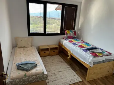 a small bedroom with a bed and a chair at Apartament Armada Bansko in Bansko