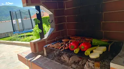 a barbecue grill with vegetables on a brick wall at Guest House Saint George in Vukovo