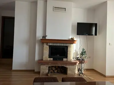 a living room with a fireplace with a flat screen tv at Apartment Danik River Glaznel in Bansko