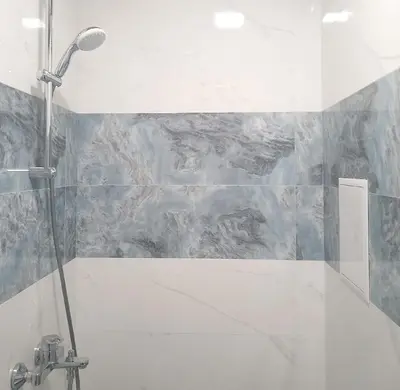 a bathroom with a shower with a tub and a wall at Alis Savana in Sofia
