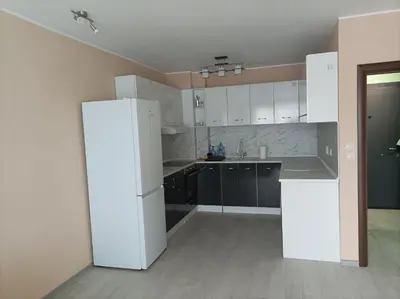 an empty kitchen with white cabinets and a refrigerator at Мариана in Plovdiv