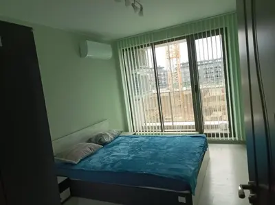 a bed in a room with a large window at Мариана in Plovdiv
