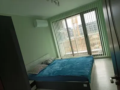 a small bed in a room with a large window at Мариана in Plovdiv