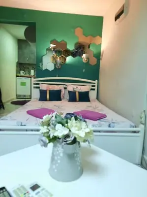 a bedroom with a bed with a vase of flowers on a table at Studio for guests Catherine in Sofia