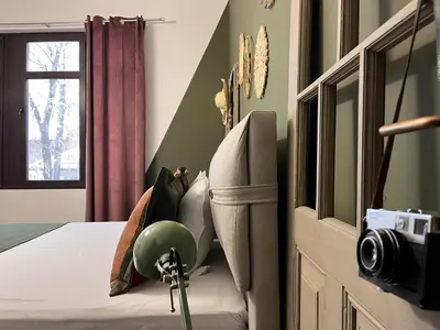 a bedroom with green walls and a bed with a camera at Diva Kapana 2BDR Apartment with parking in Plovdiv