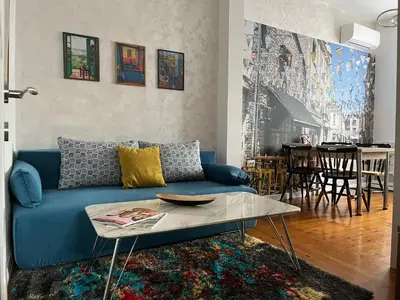 a living room with a blue couch and a table at Diva Kapana 2BDR Apartment with parking in Plovdiv