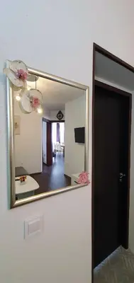 a mirror in a room with a living room at АПАРТАМЕНТ ЮЛИЯ ДЕЛУКС II in Velingrad