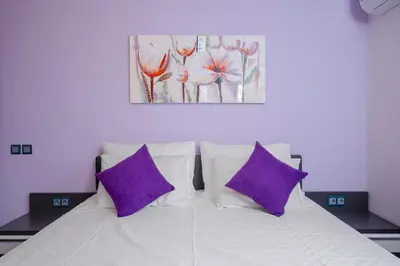 a bedroom with a white bed with purple pillows at Feel at Home - Central 2BD Flat with Parking by Flat Mаnager in Sofia