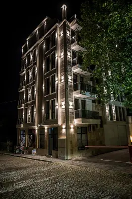 a building with lights on the side of it at night at Lux Apart Karlovo 1 in Karlovo