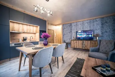 a kitchen and dining room with a table and chairs at Lux Apart Karlovo 1 in Karlovo