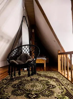 a swing chair in a room with a rug at Lambievi Kolibi in Gorno Kraishte