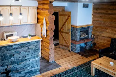 a living room with a fireplace in a log cabin at Lambievi Kolibi in Gorno Kraishte