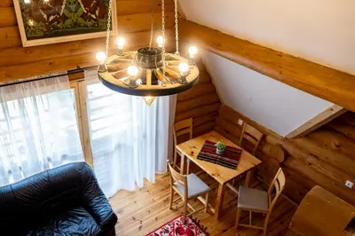 a living room with a table and a chandelier at Lambievi Kolibi in Gorno Kraishte