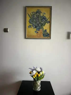 a vase of flowers on a table with a painting at Brand NEW! 2BDR Lux Apartment RAYKO in Sofia
