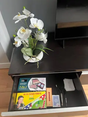 a table with a vase with white flowers and books at Brand NEW! 2BDR Lux Apartment RAYKO in Sofia