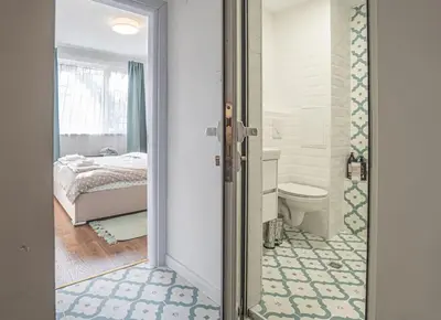 a bathroom with a door leading to a bedroom at Cozy Apartment Overlooking The Park in Sofia