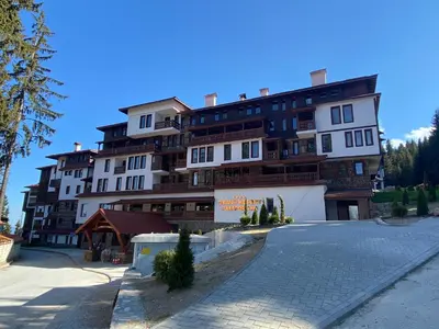 a large building with a parking lot in front of it at Pamporovo mountain apartment in Pamporovo