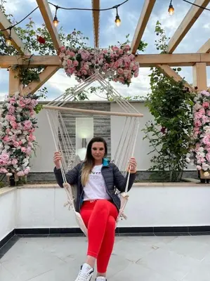 a woman is sitting on a swing at Boris House 5 bed Villa & Private Pool in Strumyani