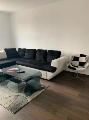 a living room with a black and white couch and a chair at Luxury Apartment Eleni in centre of Sandanski in Sandanski