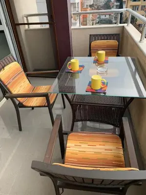 a table and chairs with yellow cups on a balcony at Luxury Apartment Eleni in centre of Sandanski in Sandanski