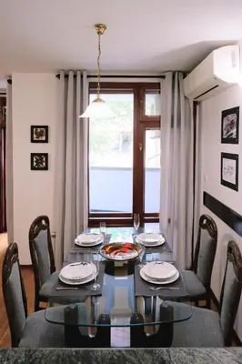a dining room with a table and chairs and a window at Домът на архитекта The Architect's Home in Plovdiv