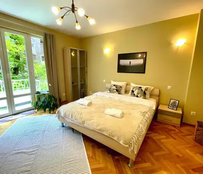 a bedroom with a large bed and a large window at Bohemian Bright & Calm 2BR - Top center - Private Balcony in Sofia