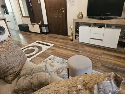 a living room with a couch and a television at Bright Inn - Holiday & Business Apartment in Sofia