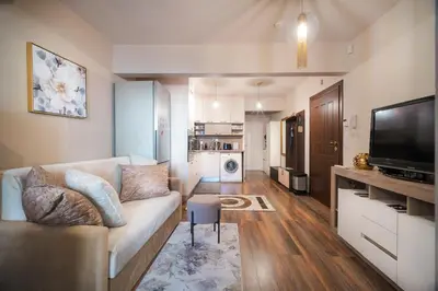 a living room with a couch and a flat screen tv at Bright Inn - Holiday & Business Apartment in Sofia
