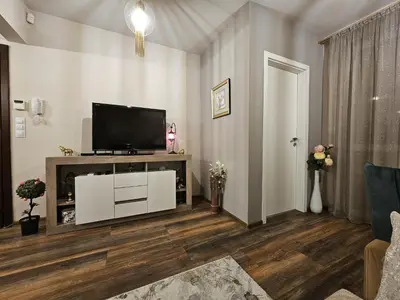 a living room with a flat screen tv on a entertainment center at Bright Inn - Holiday & Business Apartment in Sofia