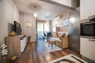 a living room with a couch and a television in it at Bright Inn - Holiday & Business Apartment in Sofia