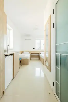 a kitchen with white tile flooring and wooden cabinets at Millennia Hotel in Sofia