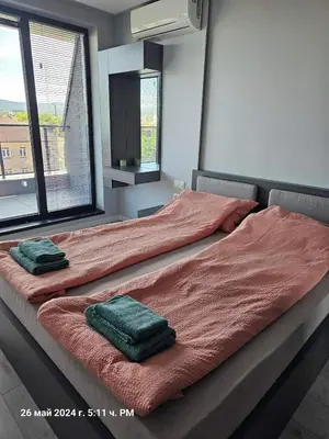 a large bed with two green pillows on it at Dilyanka 2 in Pernik