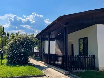 a building with a black fence next to a yard at Bungalows of Yug in Kyustendil