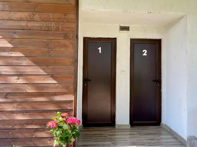 two doors on a building with flowers in a vase at Bungalows of Yug in Kyustendil
