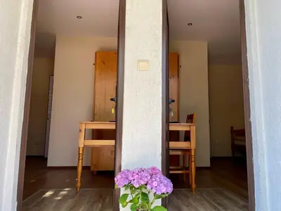 a mirror in a room with a vase of purple flowers at Bungalows of Yug in Kyustendil