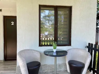 a table and two chairs and a table and a window at Bungalows of Yug in Kyustendil